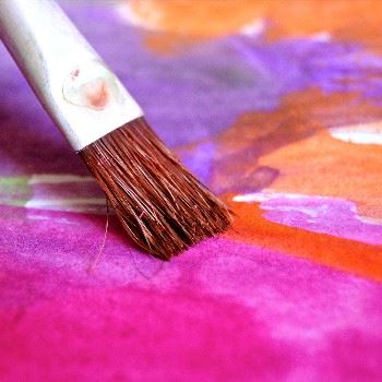 paintbrush painting bright pink and orange watercolors