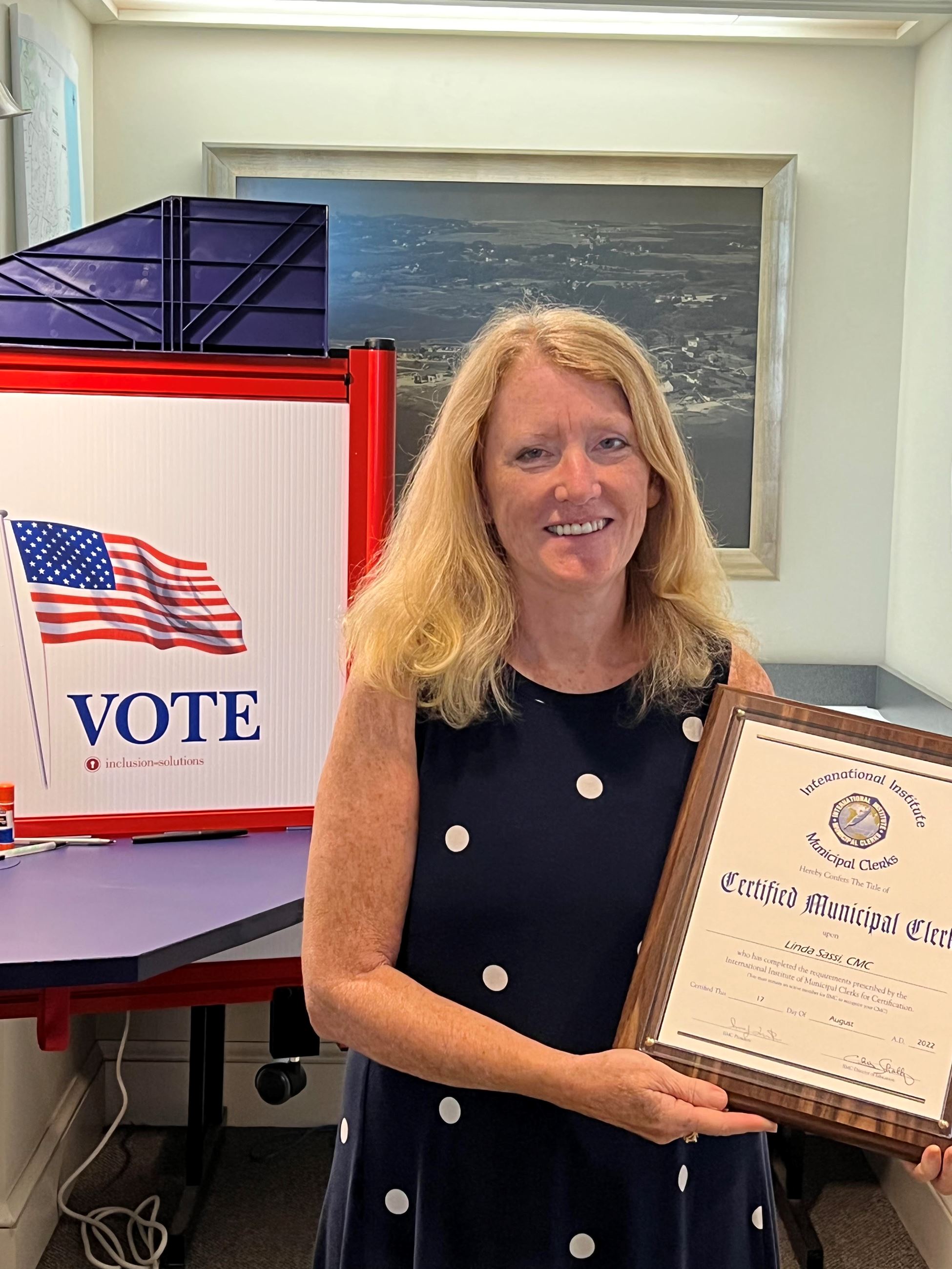 Linda Sassi smiling and holding her clerk certificate